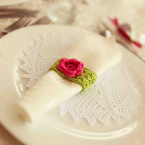 42357647 - green and fuchsia wedding napkin an table